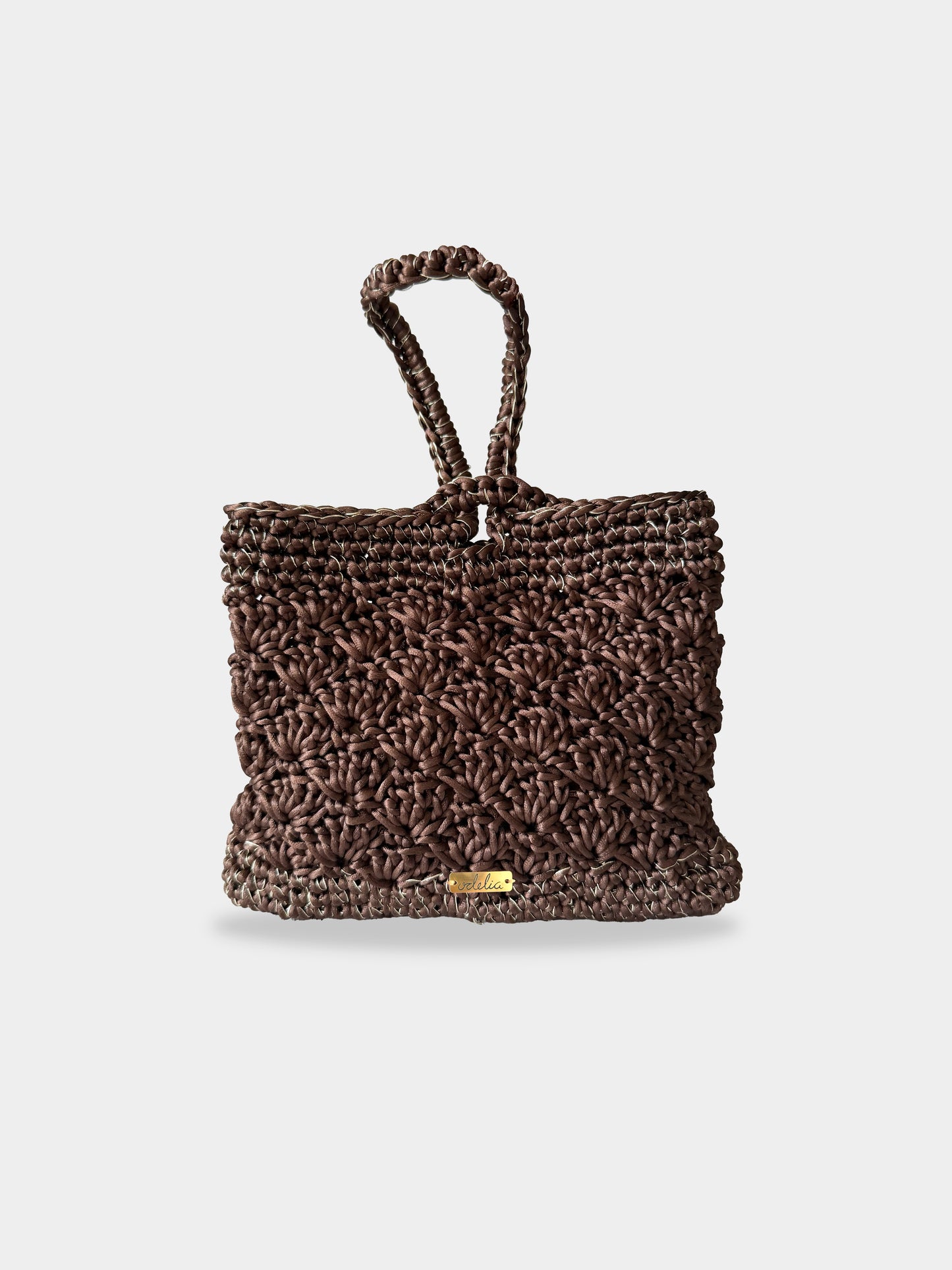 Bolso tejido de color marrón con detalles dorados, ideal para eventos